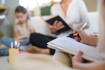 Eine Frau und zwei Kinder arbeiten gemeinsam für die Schulee